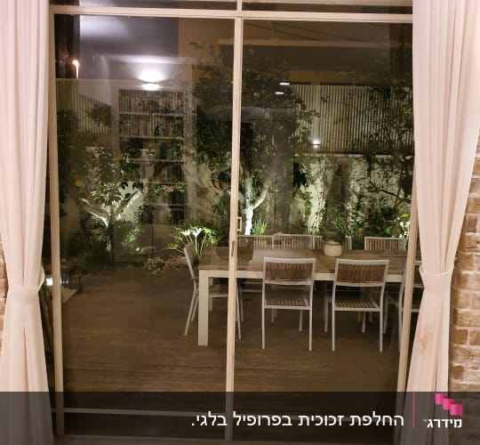 דלת זכוכית גדולה עם וילונות לבנים בצדדים